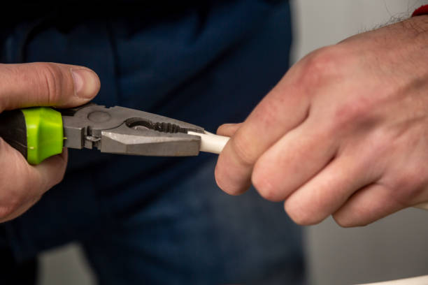 istock Work with green pliers and a white cable. Hands in the frame. Close-up. Horizontal orientation 1224229842