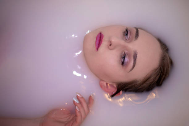 istock An attractive model takes a bath with milk and apple petals. 1224231443