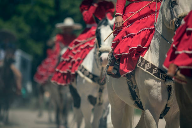 A small group of charra cowgirls riding white horses.