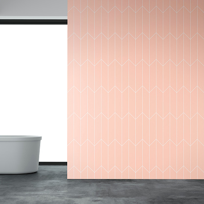 Bathroom interior on gray concrete floor and empty peach pink and white tiled wall with copy space. Self-standing bathtub on the left and windows in background. 3D rendered image.