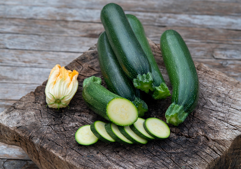 Group of organic zucchini with slices on wood