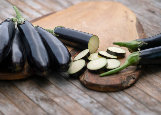 berenjenas orgánicas sobre fondo de madera - eggplant fotografías e imágenes de stock