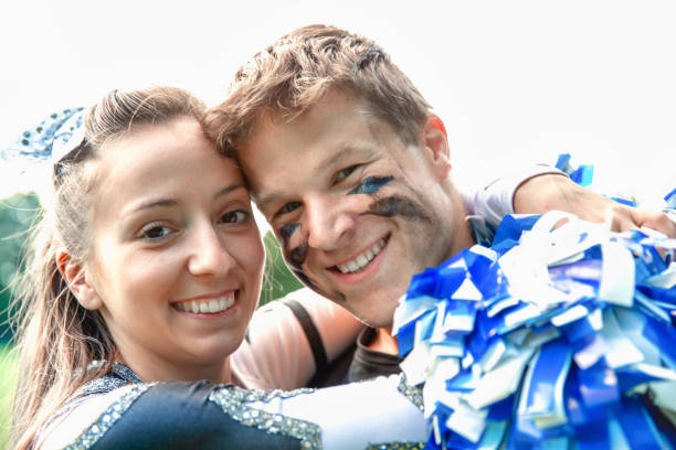 American Football Player and Cheerleader Girl in Love Happy smiling young couple - American Football Player and Cheerleader Girl together. Embracing each other after the Football Game. American Football Lifestlye Shoot. football player girlfriend stock pictures, royalty-free photos & images