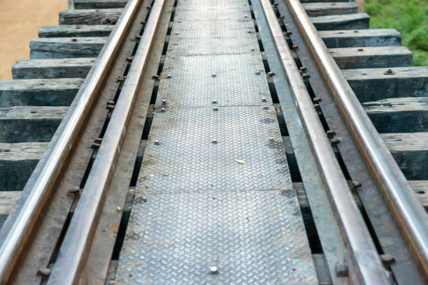 Rail track with wooden sleepers and rusty rails at old railway bridge