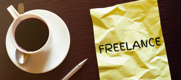istock Work place. Pen, cup of coffee and paper with FREELANCE text 1224239947