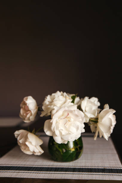 istock white roses bouquet in glass jar on gray table runner and kitchen table 1224241159