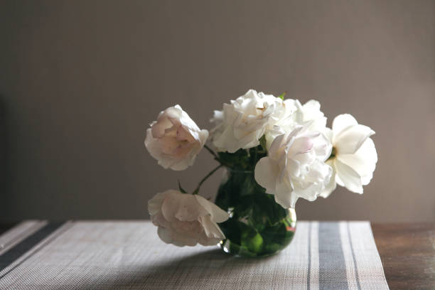 istock white roses bouquet in glass jar on gray table runner and kitchen table 1224241303