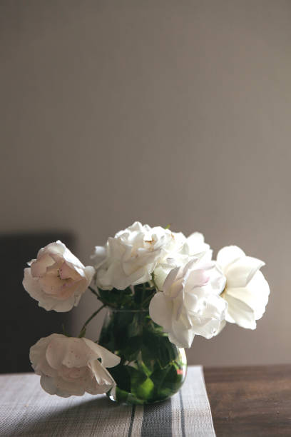 istock white roses bouquet in glass jar on gray table runner and kitchen table 1224241333
