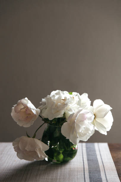 istock white roses bouquet in glass jar on gray table runner and kitchen table 1224241350