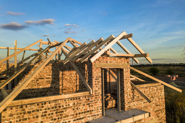 istock Private residential house with wooden roof frame structure under construction. Unfinished brick building under development. 1224248027