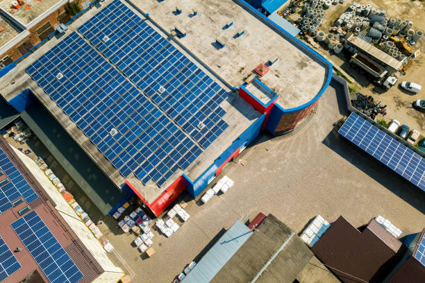aerial view of many photo voltaic solar panels mounted of industrial building roof. - voltaic imagens e fotografias de stock