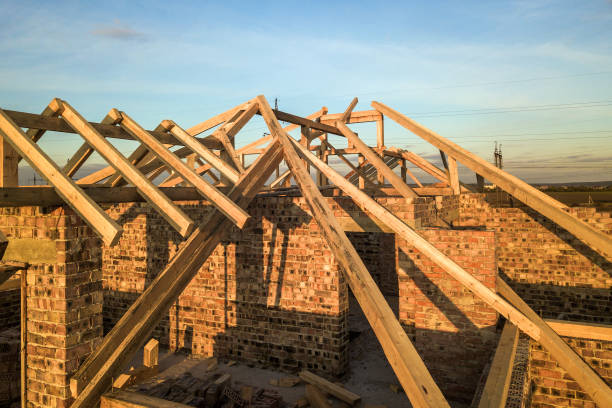 istock Private residential house with wooden roof frame structure under construction. Unfinished brick building under development. 1224248039