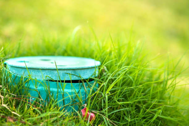 zbliżenie zielonej rury z tworzywa sztucznego z pokrywą na zielonym trawniku trawiastym. - sprinkler park summer spray zdjęcia i obrazy z banku zdjęć
