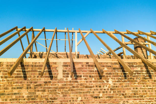 istock Unfinished brick house with wooden roof structure under construction. 1224248114