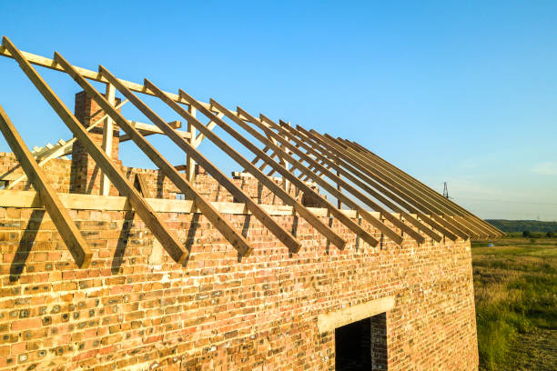 istock Unfinished brick house with wooden roof structure under construction. 1224248117