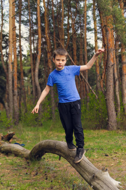 istock boy walks on a log and learns to keep balance 1224248126