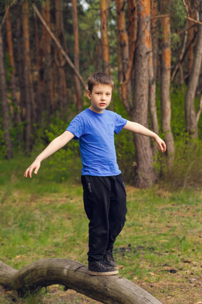 istock boy walks on a log and learns to keep balance 1224248128
