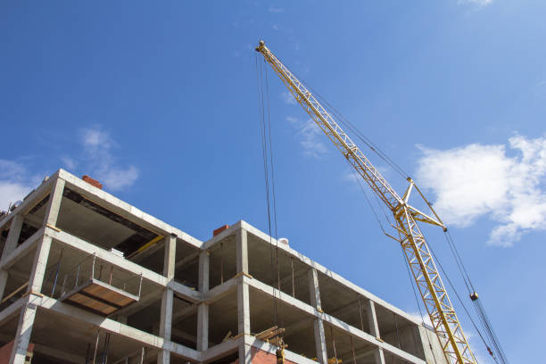 istock Construction technologies. Construction of a building made of reinforced concrete and a construction crane against the blue sky 1224248220
