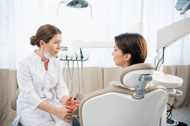 Female dentist discussing a report with her patient at the clini stock photo