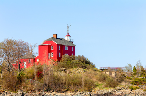 Red lighthouse on Lake Superior shore.  The historic Marquette Harbor Lighthouse in Marquette, Upper Michigan.  Room for copy if needed.