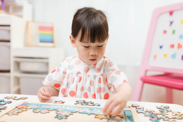 istock toddler girl playing wooden puzzle at home 1224251421