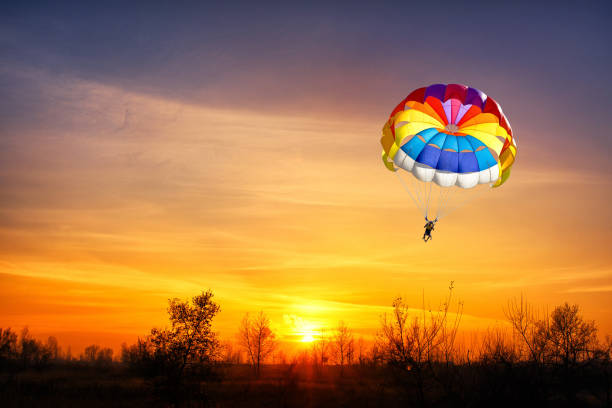 istock Paragliding with a parachute on the background of sunset. 1224252417