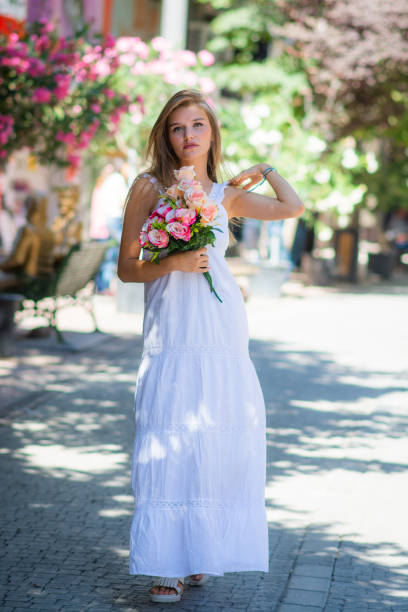 portrait of young blonde beautiful woman with flower crown on her head outdoors