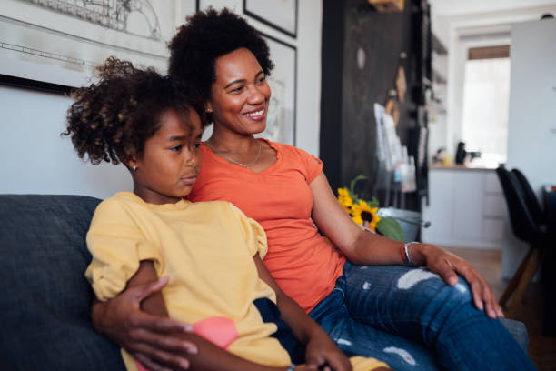 istock Mother with her daughter at home, watching TV 1224255137