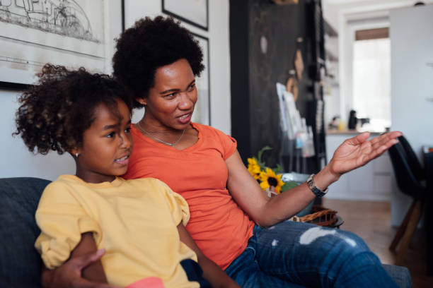 istock Mother with her daughter at home, watching TV 1224255142