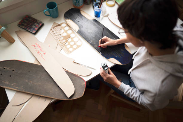 istock Young woman painting on skateboard plank in her workshop 1224255217