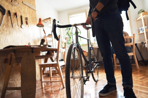 istock Man with a backpack and a bicycle leaves his workshop 1224255226