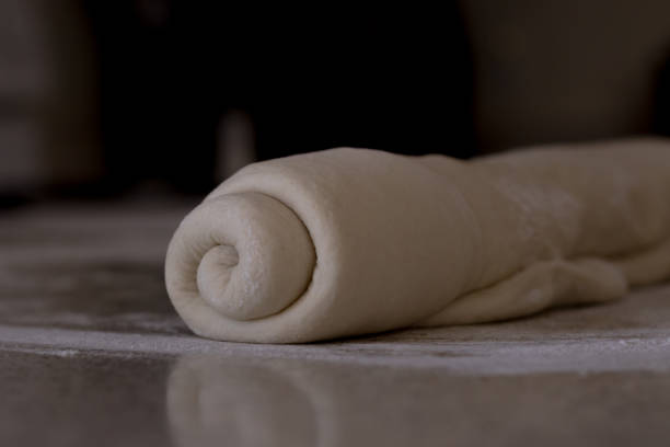 istock Rolled bread dough on a floured kitchen counter waiting to be shaped into a loaf of bread. 1224258069