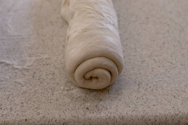istock Rolled bread dough on a floured kitchen counter waiting to be shaped into a loaf of bread. 1224258070