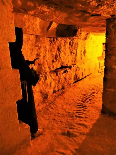 Orange light and shadow in parisian catacombs