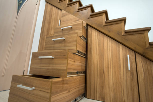 istock Modern architecture interior with luxury hallway with glossy wooden stairs in multi-storey house. Custom built pullout cabinets on glides in slots under stairs. Use of space for storage. 1224260892