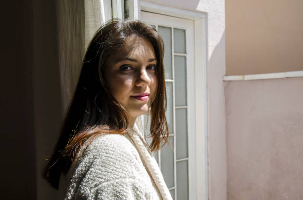 istock Young woman by the window 1224261134