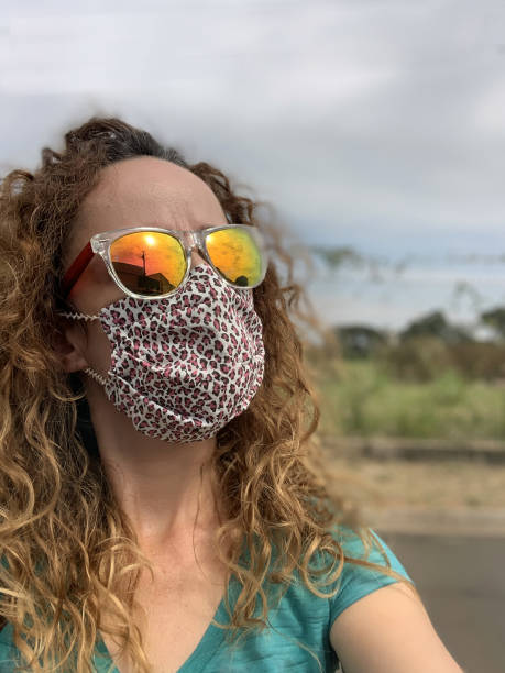 donna con maschera protettiva in tessuto. - vertical caucasian glasses red hair foto e immagini stock