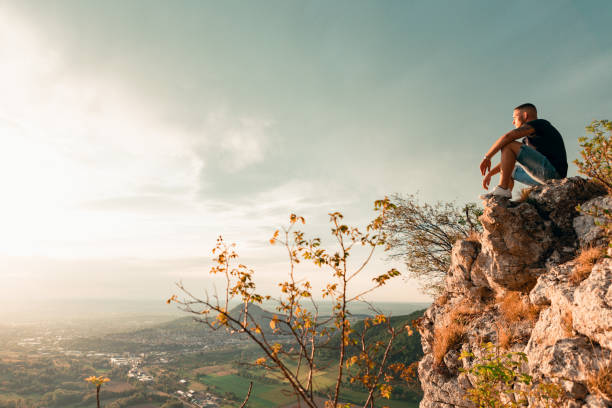 istock Confident Young Man Sitting on the Edge of a Cliff 1224264581