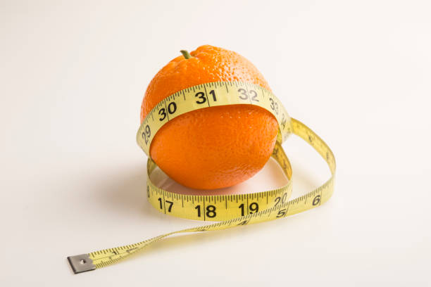 weight loss solution concept. orange with measure tape. good source of vitamin c - textile healthy eating instrument of measurement tape measure imagens e fotografias de stock