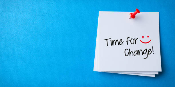 istock White Sticky Note With Time for Change And Red Push Pin On Blue Background 1224269593