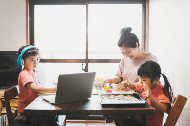 istock Boy wearing headset taking an e-Learning course with family in the living room 1224277480
