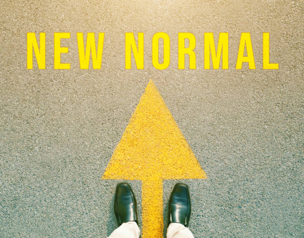 Foot and arrow on the road that says "New Normal". Concept new life after the outbreak of the Covid-19 virus. Foot and arrow on the road that says "New Normal". Concept new life after the outbreak of the Covid-19 virus. new normal concept stock pictures, royalty-free photos & images