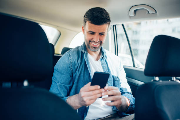 istock Man using phone in a taxi 1224282263
