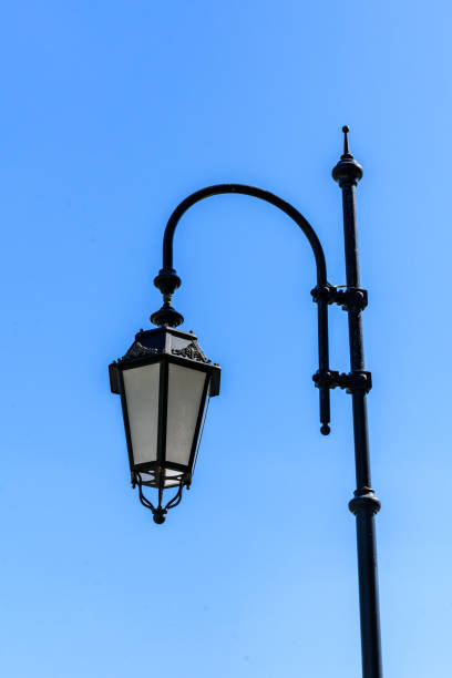 istock Old lantern on a metal post against blue sky 1224282566