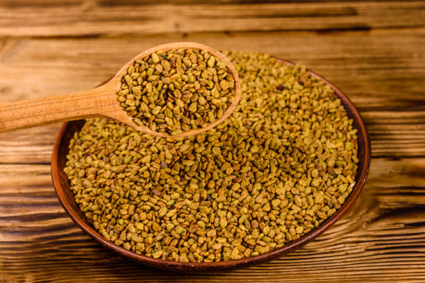 istock Ceramic plate and spoon with fenugreek seeds on wooden table 1224283320