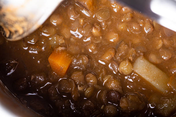 Lentils potage homemade close up still with a metal spoon on a pot