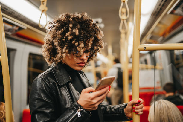 istock Beautiful young woman texting in subway train 1224293999