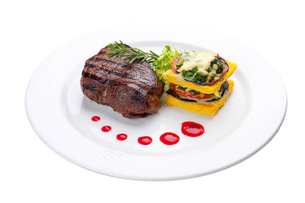 istock Beef steak with grilled vegetables and an omelette. On a white plate 1224294156