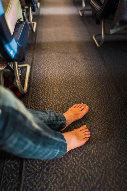 Actually there are several things that you shouldn't do on an airplane but this time I choose "barefoot".
Do NOT walk around barefoot. Floor must be full of germs. Also putting barefoot on tray table is horrifying. Unfortunately there are inconsiderate passengers....