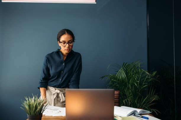 istock Serious businesswoman looking on a laptop screen while standing at a table 1224300145
